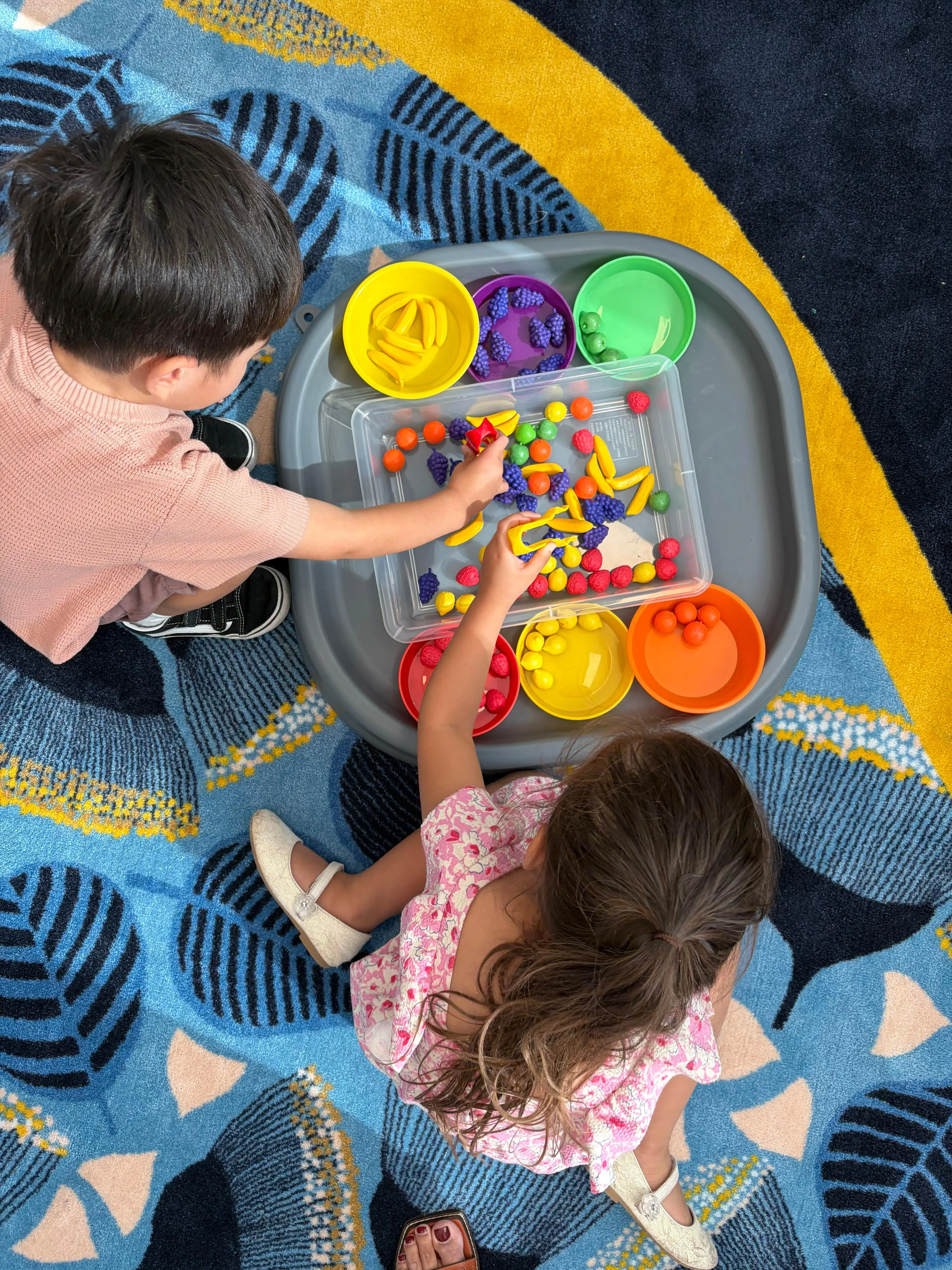 Early learners exploring with fruit toys at New Era Education